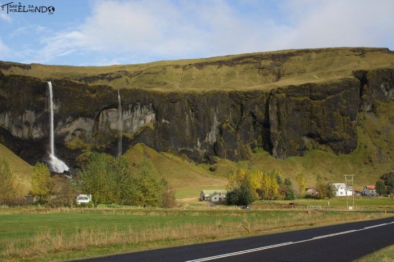 Montaña con cascadas a orilla de una carretera de asfalto